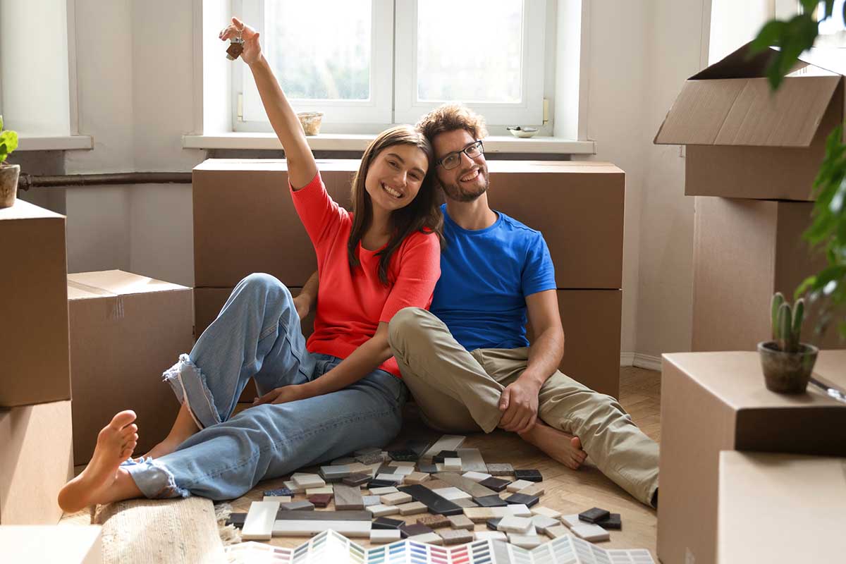 Pareja de jóvenes sosteniendo las llaves de su nueva casa