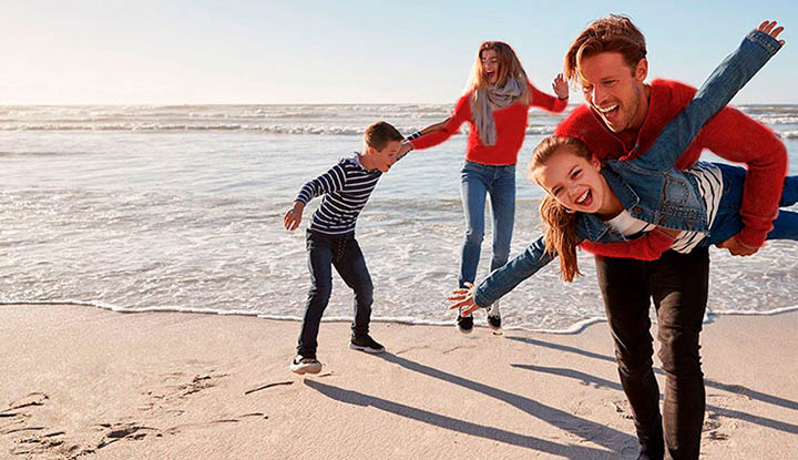 Padres con sus hijos jugando en la playa