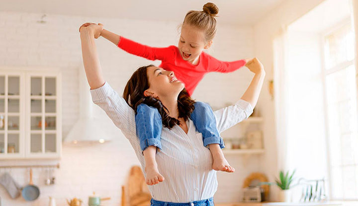 Madre e hija jugando mientras disfrutan de su hogar