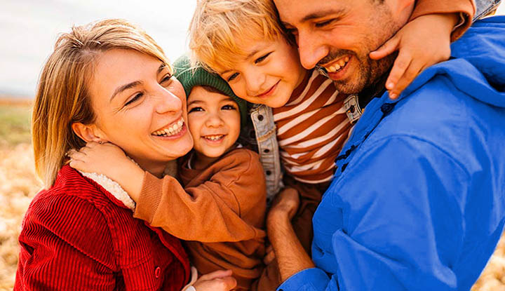 Familia de dos padres y dos niños abrazandose Familia de dos padres y dos niños abrazandose