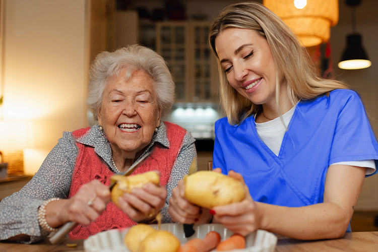 Dos personas, una mayor y otra joven, disfrutando cocinando juntas