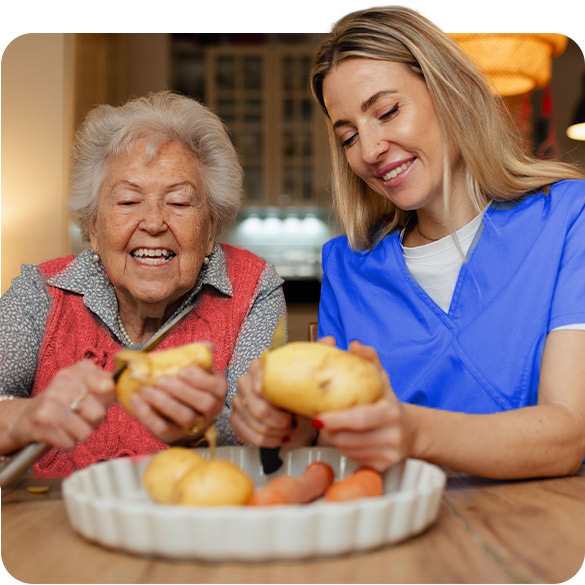 Dos personas, una mayor y otra joven, disfrutando cocinando juntas