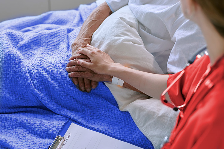 Profesional ofreciendo a una persona mayor cuidados paliativos