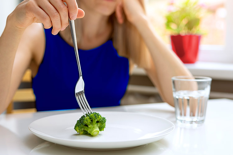 Imagen de una joven con comida en el plato