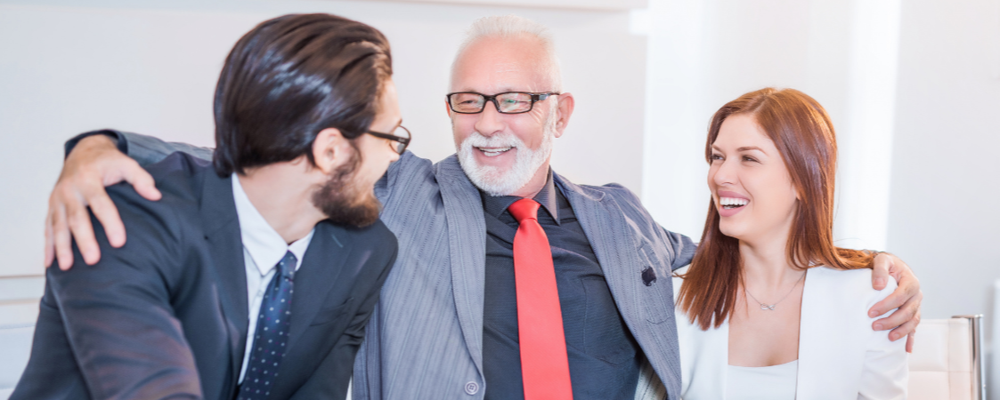 Padre e hijos empresarios sonríen mirando ordenador