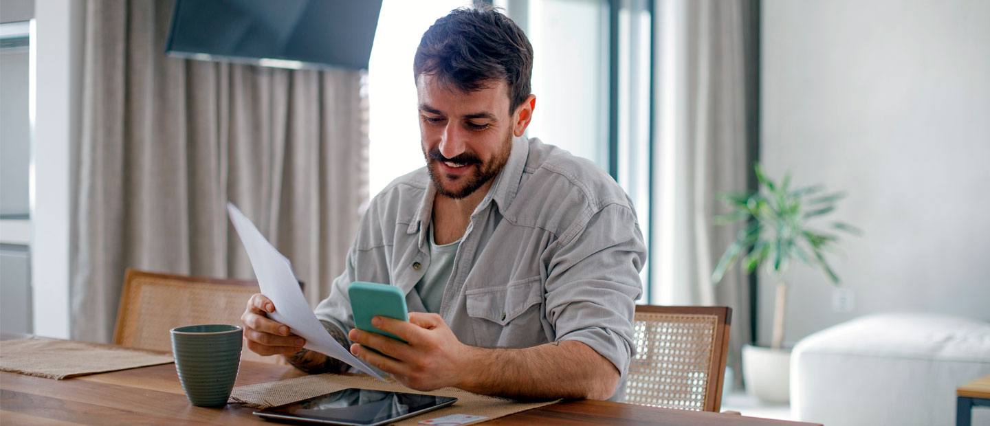 Hombre mirando papeles y teléfono