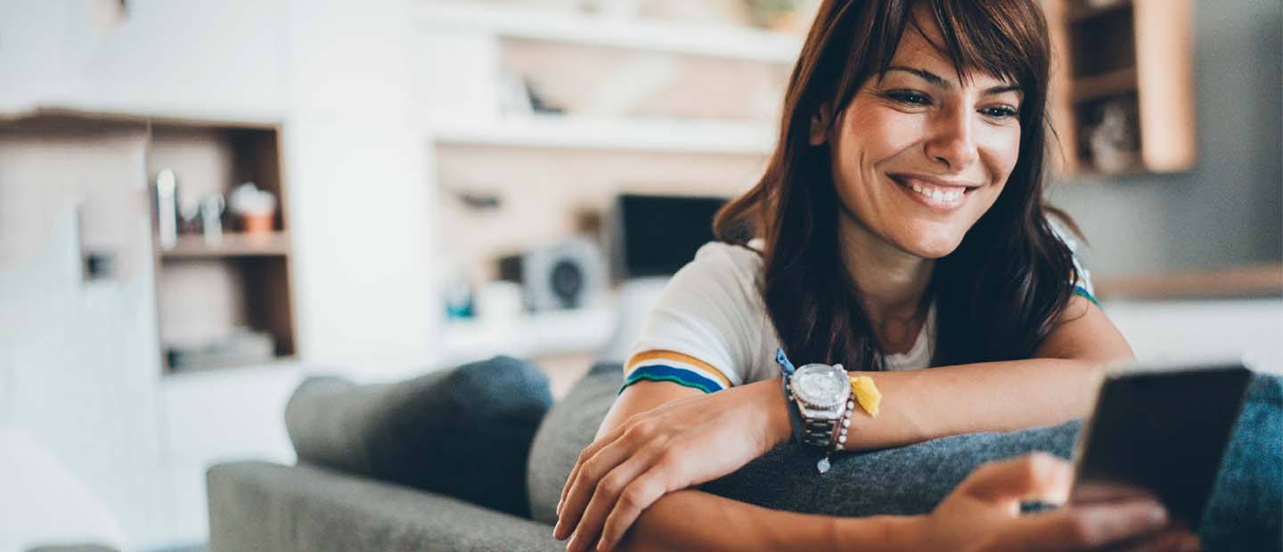 Chica sonriente mirando el móvil