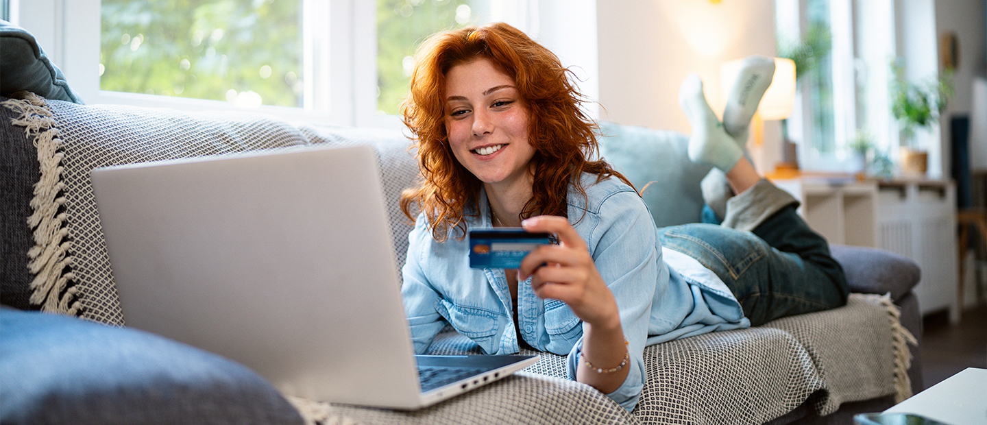 Chica mirando el ordenador con su tarjeta