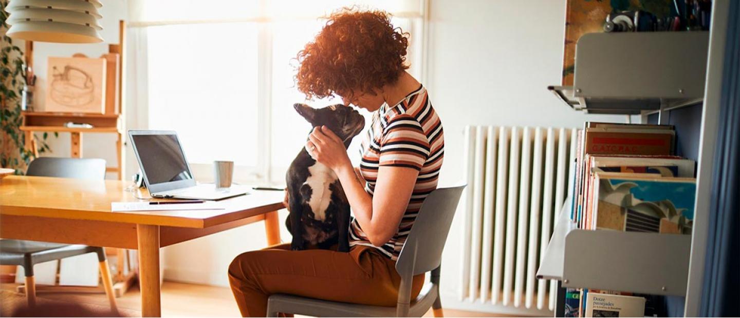 Chica con un perro en casa dándole cariño
