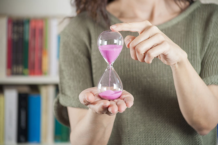Mujer con un reloj de arena en la mano