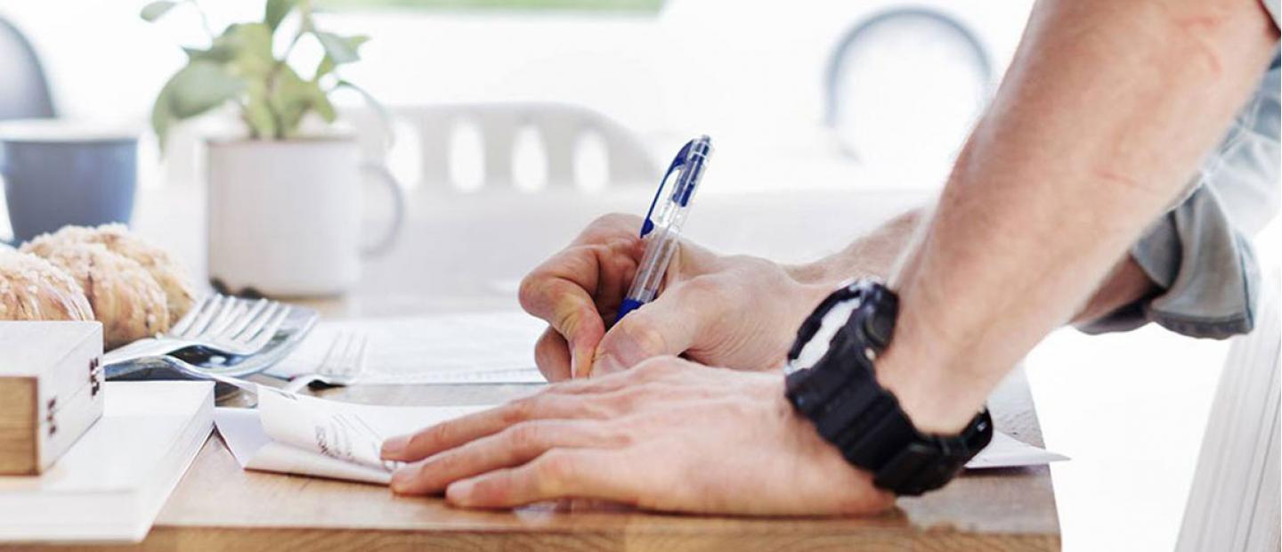 Joven firmando y solicitando una hipoteca