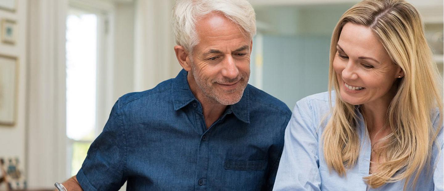 Imagen mujer y hombre sonriendo mientras revisan unos papeles
