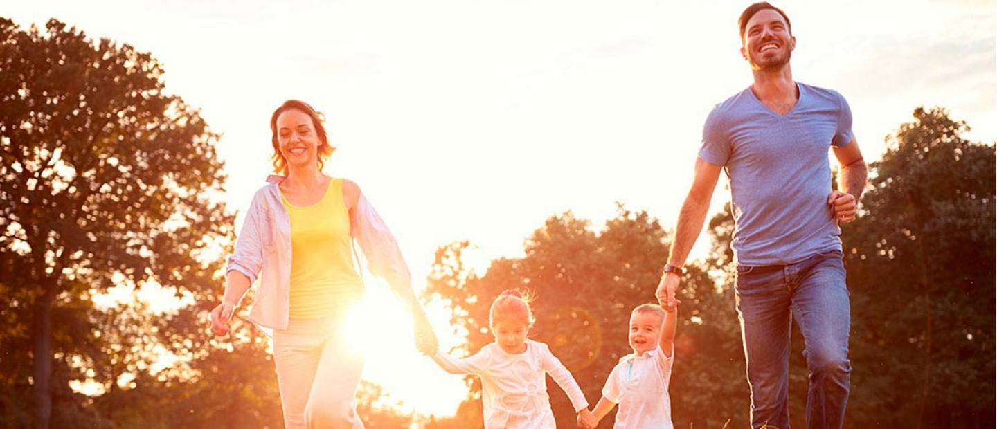 Imagen pareja con dos bebes corriendo en el parque