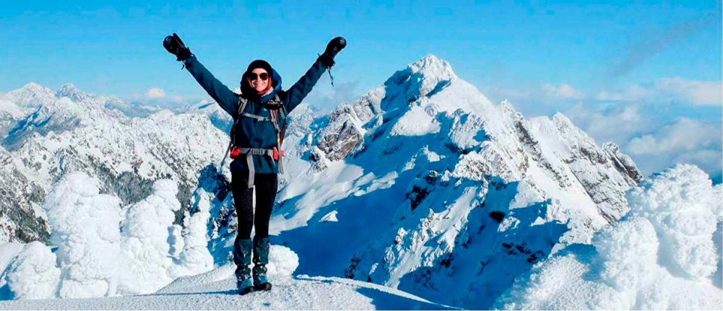 Imagen mujer en lo alto de la montaña con nieve