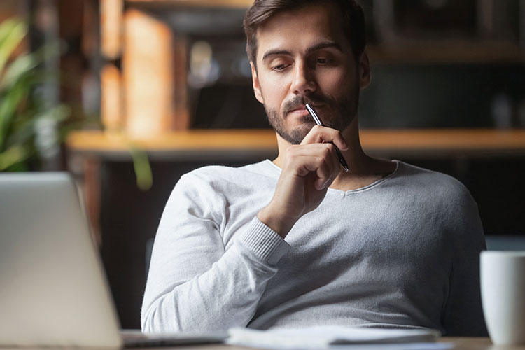 Imagen hombre joven pensado frente a su ordenador
