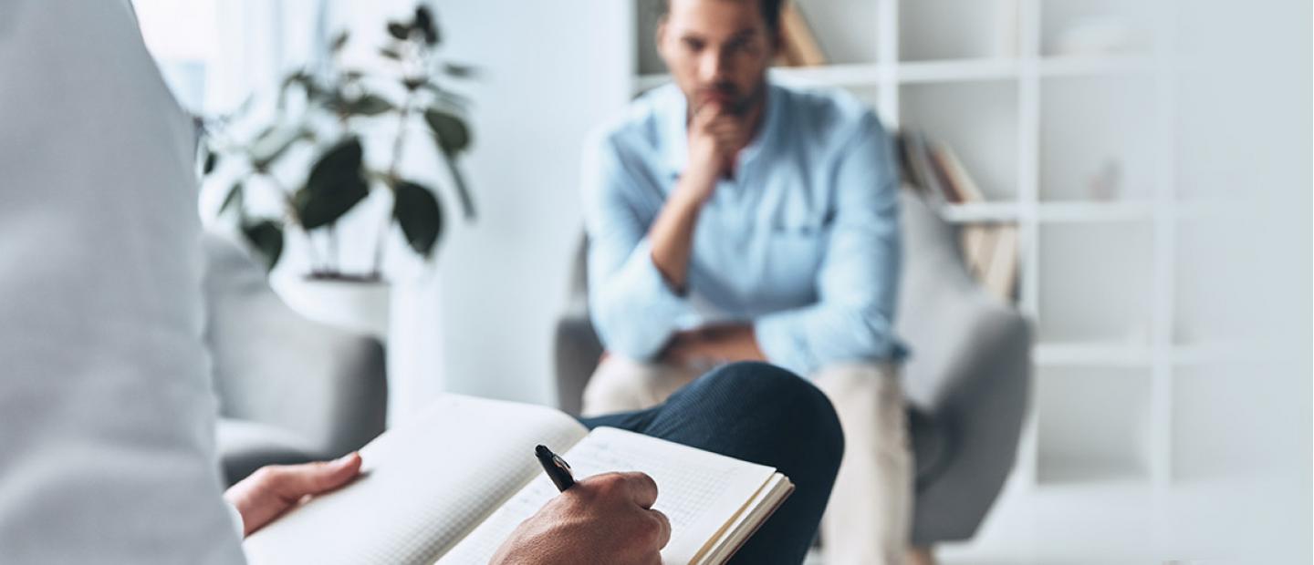 Imagen hombre pensando una silla mientras otra persona toma nota en su cuaderno