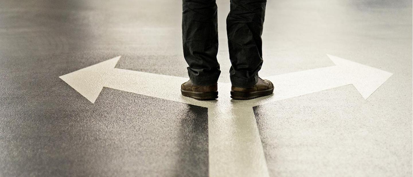 Imagen persona encima de flecha con dos direcciones