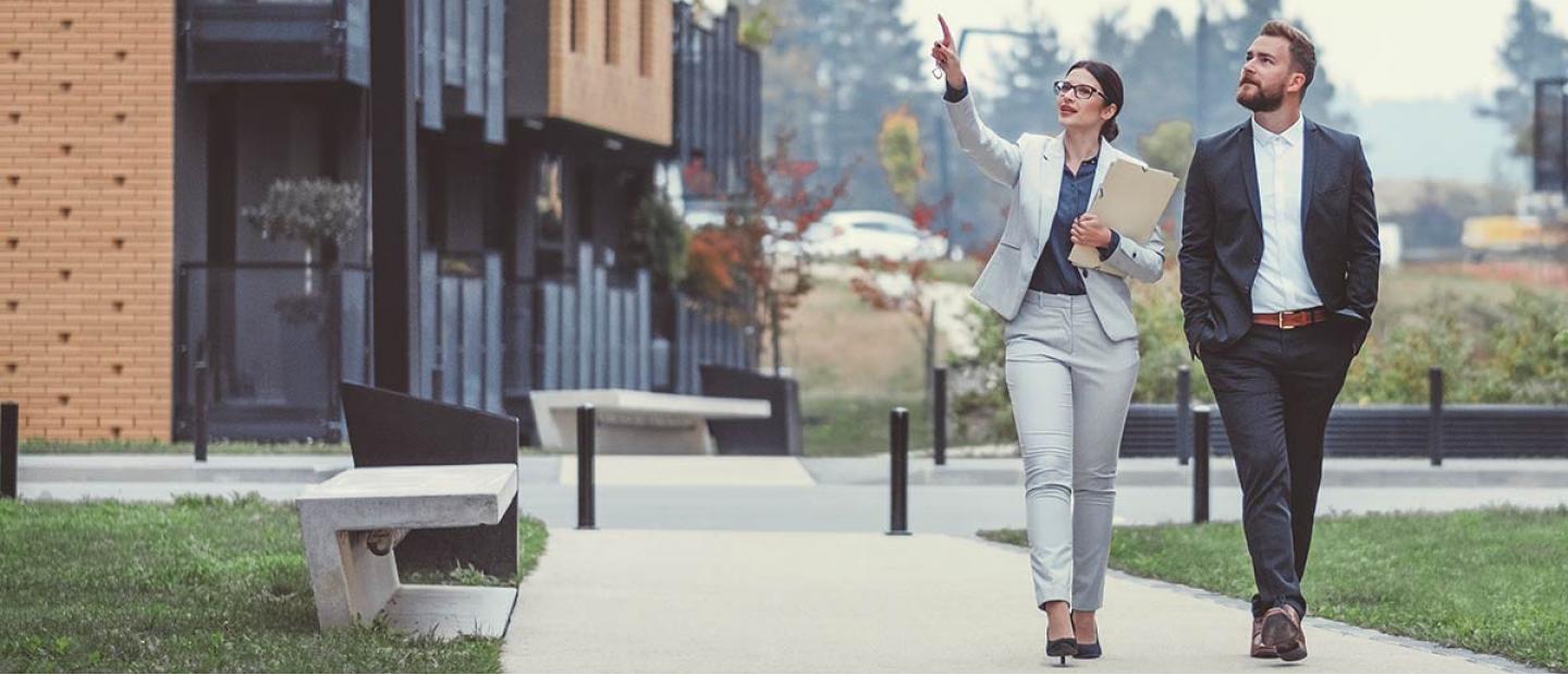 Imagen una mujer y un hombre con traje paseando por la calle