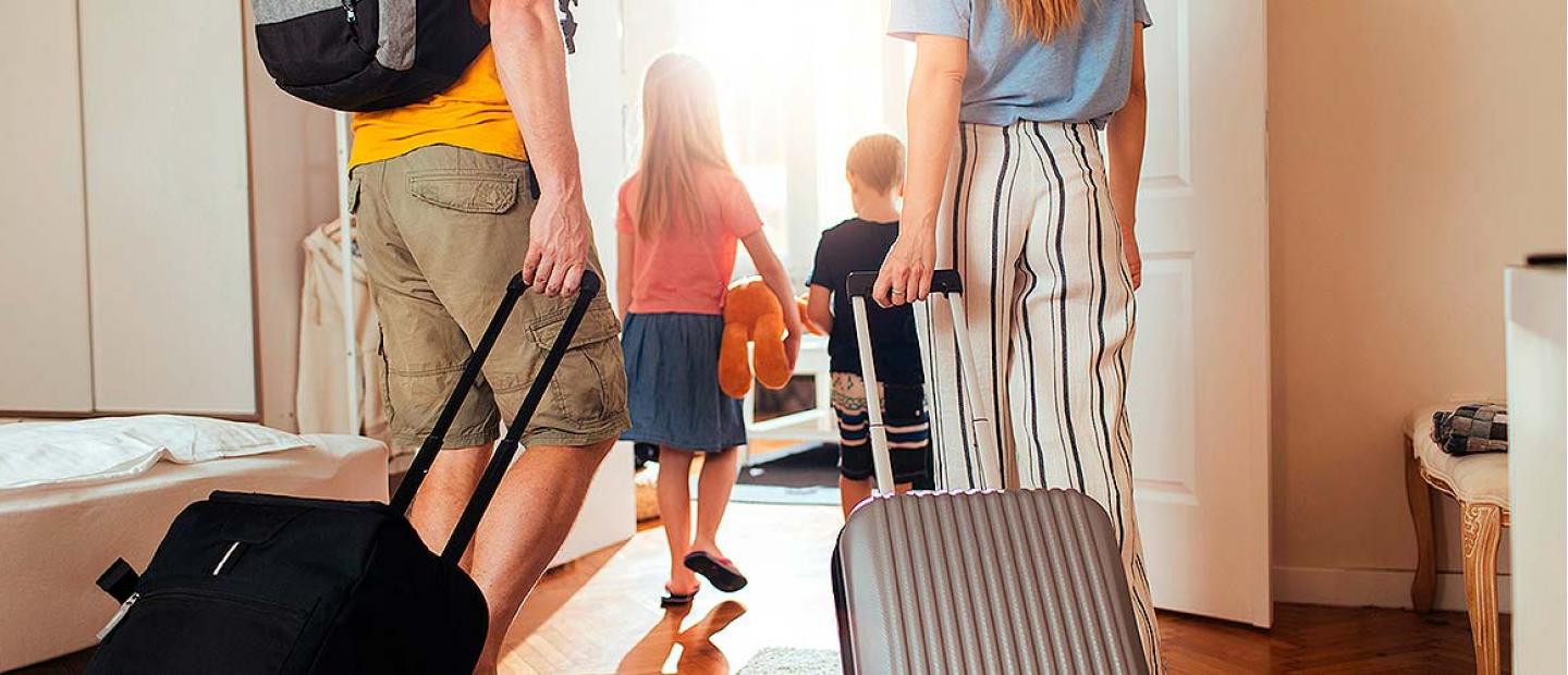 Imagen familia yendose de vacaciones con las maletas