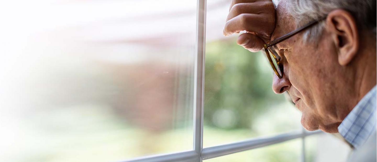 Imagen persona de avanzada edad mirando por la ventana