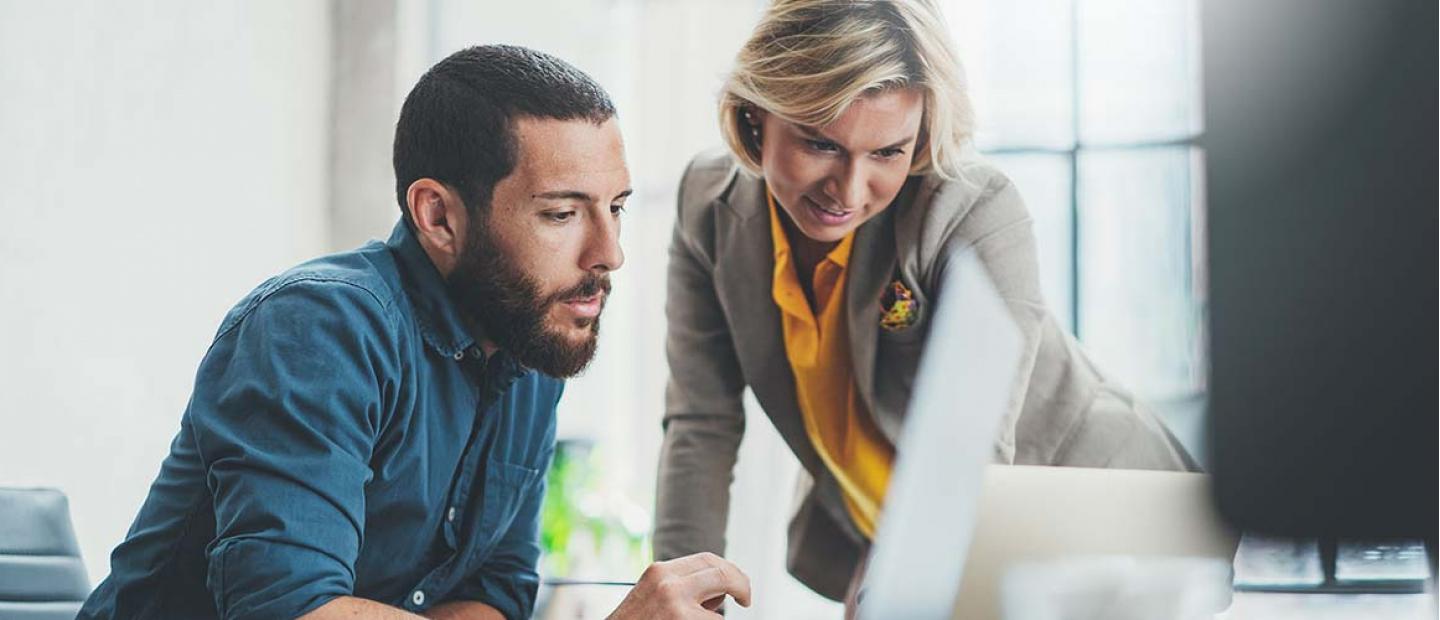 Imagen mujer y hombre revisando el ordenador en la oficina
