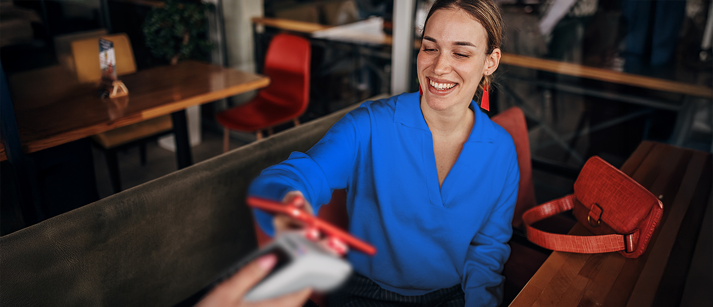 Joven paga con tarjeta en un TPV Android en un restaurante