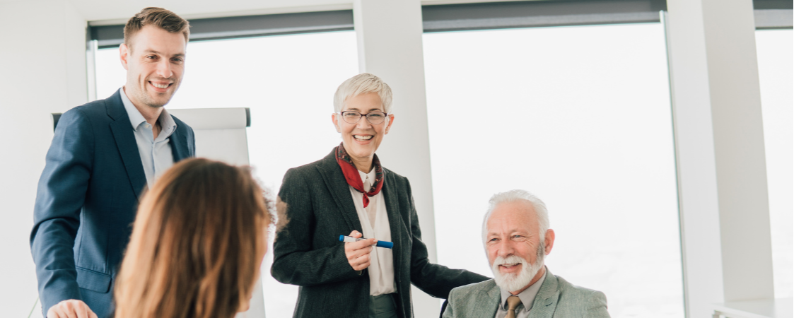 Dos hombres y dos mujeres sonriendo mientras se reunen