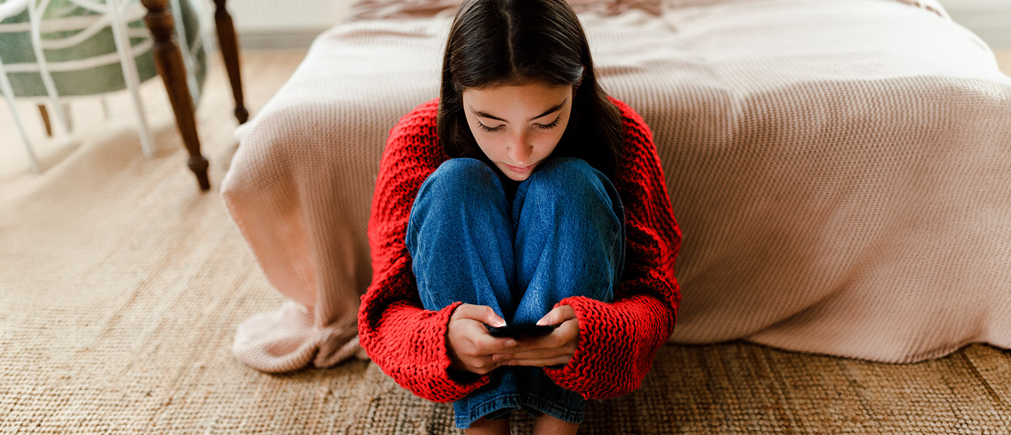 Joven utilizando su móvil en su habitación