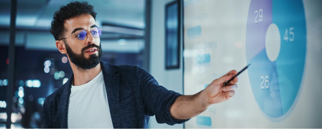 Joven enseñando unas gráficas de empresa