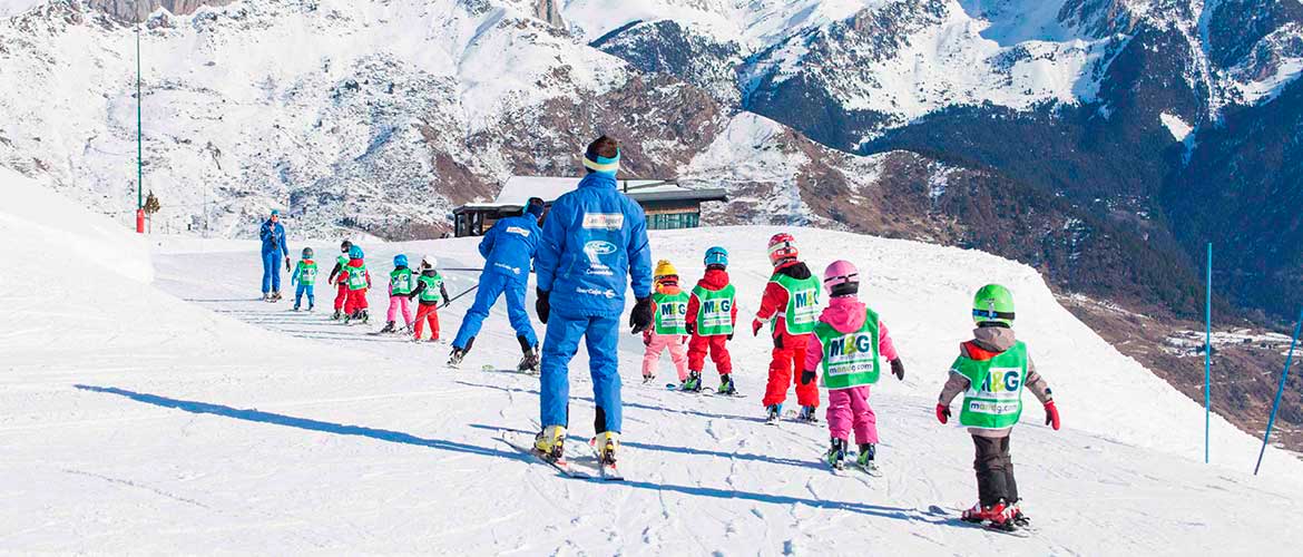 Grupo de niños esquiando con casco en Formigal