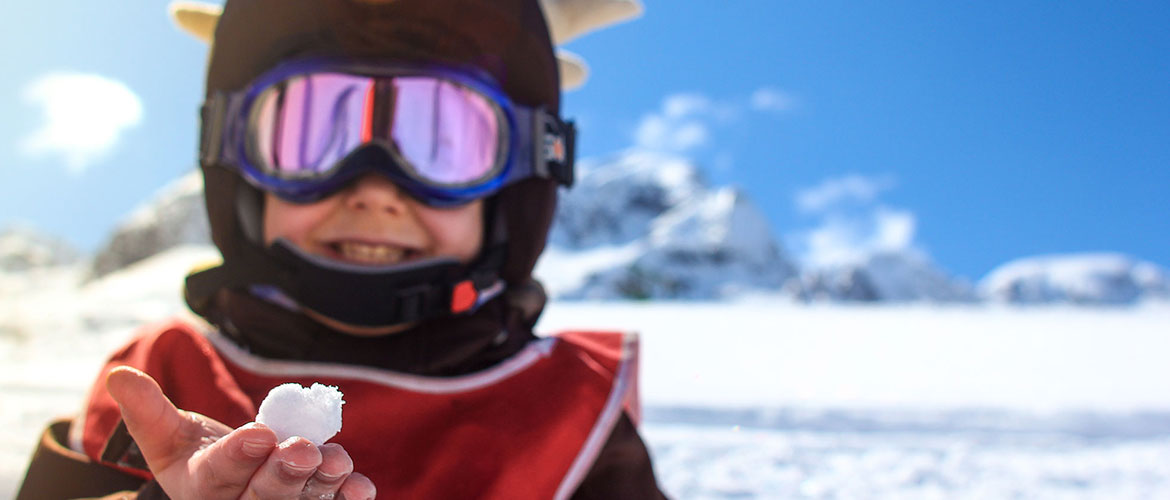 Niño en la nieve con ropa de esquí